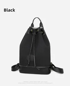 Detail of black oxford fabric backpack featuring drawstring closure and leather trim accents