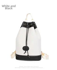 Close-up of white Oxford fabric backpack with black leather trim and drawstring closure