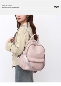 Detail view of pink PU leather backpack with multiple zipper pockets on a female model