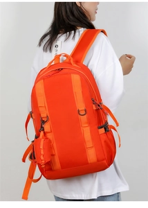 Detail of orange hiking backpack featuring side pocket and functional metal D-ring