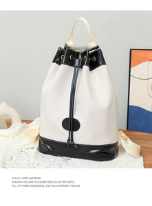 Detail view of monochrome drawstring bucket backpack featuring matte PU leather and black base