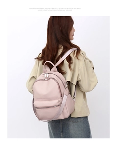 Rear view of a model wearing a pink PU leather backpack with multi-pocket functional design