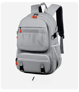 Detail view of the gray backpack showing the mesh front pocket and orange zipper pulls