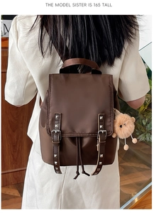 Brown nylon backpack worn by a 165cm model featuring rivets and a plush bear charm