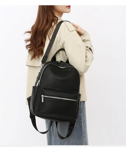 Detail of black PU leather backpack showing lychee texture and silver zipper hardware