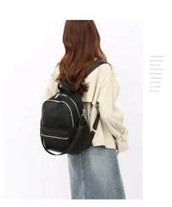 Model back view showing black PU leather backpack with multi-pocket zipper design