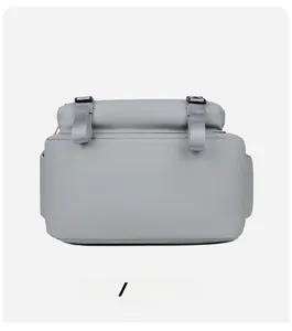 Detail view of the backpack base with adjustable grey straps and orange zipper accents