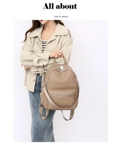 Close-up of khaki PU leather backpack with multiple zipper pockets and adjustable straps