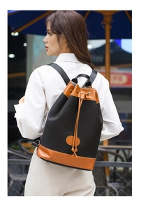Detail view of water-resistant nylon bucket backpack with brown leather trim details