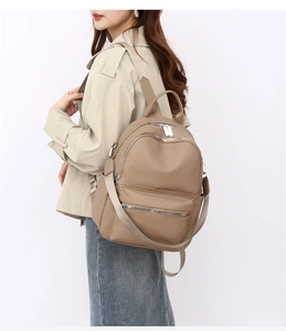 Detail view of large PU leather backpack featuring side pockets and multi-zipper compartments