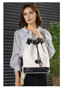 Detail view of contrast color bucket backpack with drawstring closure and fabric straps