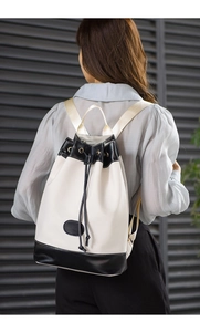 Rear view of a model wearing the high-capacity drawstring bucket backpack in contrast colors