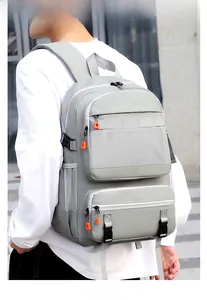 Detail of light grey multi-functional travel backpack with orange zipper accents in outdoor use
