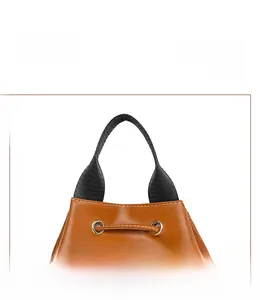 Close-up of brown leather bag with white stitching and durable metal eyelet handle