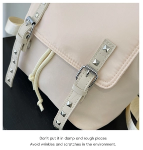 Detail of beige nylon backpack with metallic square studs and drawstring closure