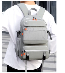 Detail of grey hiking backpack with breathable mesh pockets and orange contrast zippers