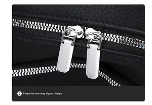 Close-up of dual silver zippers and litchi texture on black leather backpack