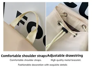 Detail of beige backpack featuring reinforced top handle and drawstring closure with metal eyelets