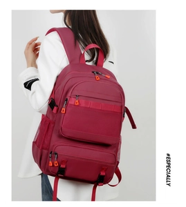 Deep red outdoor backpack with orange zipper details and functional side mesh pockets