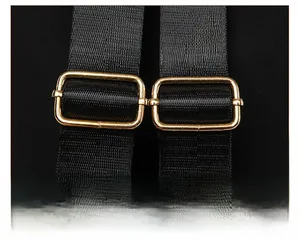 Detail of adjustable black nylon shoulder strap with gold metal buckles for the backpack