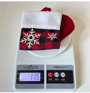 Red and black buffalo plaid Christmas stocking being weighed on a digital scale