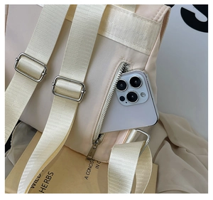 Detail of the cream backpack showing back anti-theft zipper pocket with a smartphone