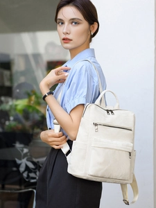 Photo lifestyle d'une femme portant un sac à dos en similicuir blanc de style minimaliste