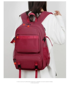 Detailed back view of a burgundy travel backpack with multiple compartments and mesh pockets