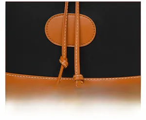 Detail view of black oxford fabric backpack with brown leather drawstring and white stitching