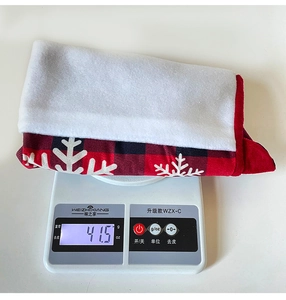 Detailed weight display of red and black plaid Christmas stocking with snowflake pattern