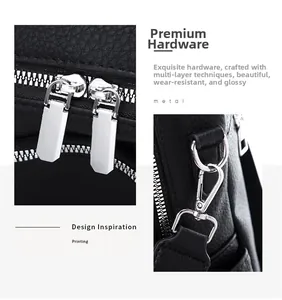 Detailed macro view of silver metal zippers and hardware on black litchi grain leather bag