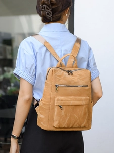 Vue détaillée d'un sac à dos vintage en cuir PU marron porté avec une chemise bleue