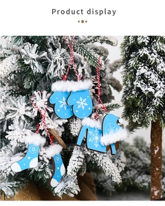 Blue and white wooden Christmas ornaments with snowflake patterns hanging on a snowy tree