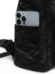 Détail de la texture plissée noire et de la poche latérale sur un sac à dos vintage chic