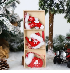 Detailed view of red wooden Christmas stocking and glove ornaments in a rustic gift box