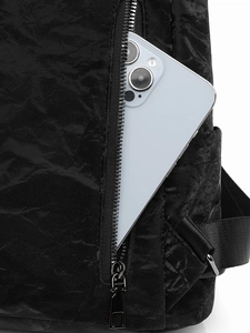 Gros plan du sac à dos noir vintage texturé avec poche latérale zippée pour smartphone