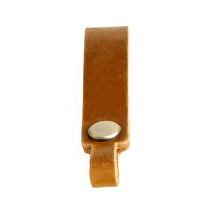 Detail of vintage brown crazy horse leather keychain with matte metal button and loop