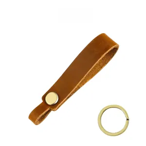 Detailed view of brown crazy horse leather strap with a matte gold snap button and key ring