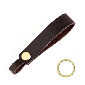 Detailed macro view of vintage brown crazy horse leather strap with golden metal key ring