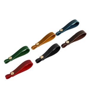 Close-up of 6 color leather drawer pulls with brass rivets in diagonal layout