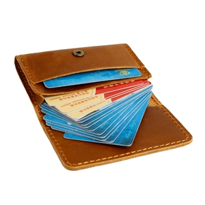 Vue détaillée du porte-cartes en cuir marron avec bouton pression en bronze et coutures