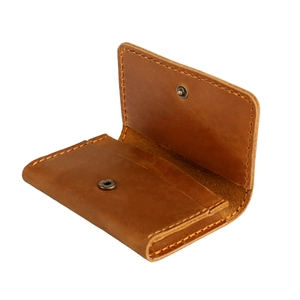 Gros plan du portefeuille en cuir crazy horse marron avec coutures à la main et bouton pression