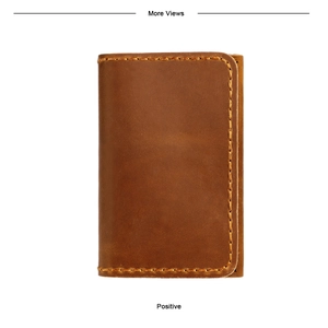 Détail d'un porte-cartes en cuir marron vintage avec des coutures jaunes robustes