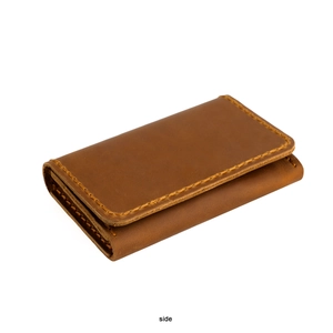Vue latérale du rangement multicouche et des coutures orange du porte-cartes en cuir brun