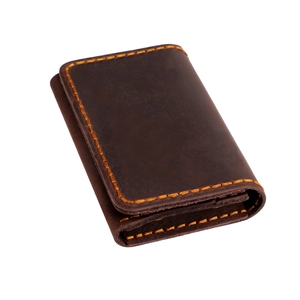 Gros plan sur le porte-cartes en cuir marron vintage avec surpiqûres jaunes