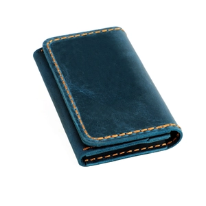 Détail du porte-cartes en cuir crazy horse bleu avec surpiqûres orange contrastées