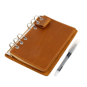 Détails macro d'un carnet en cuir marron vintage avec anneaux de reliure métalliques
