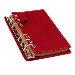 Détail du carnet en cuir rouge avec reliure à six anneaux et papier kraft de qualité