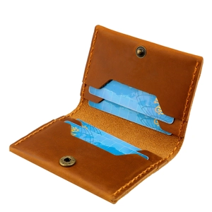 Detail of crazy horse leather card holder featuring manual stitching and brass button