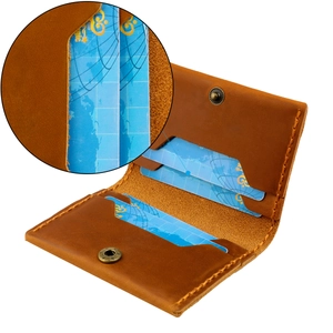 Macro detail of brown crazy horse leather card holder showing four slots and brass button